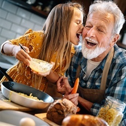 child and grandparent cooking together grandpa healthy smile after periodontal therapy
