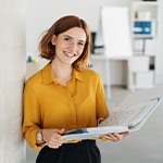 Smiling woman holding binder in office