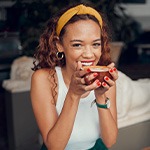 Woman smiling while enjoying cup of coffee
