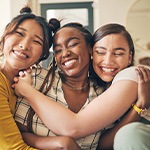Group of friends smiling while hugging on couch