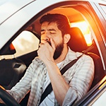 man yawning while driving 