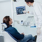 Dentist and male patient looking at digital x-rays