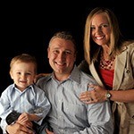 mother and father holding child smiling after dental checkups