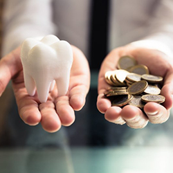 Tooth being balanced against a pile of coins