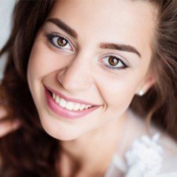 brunette lady smiling with porcelain veneers