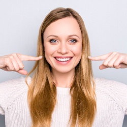 Woman pointing to smile after visiting dentist in Grapevine