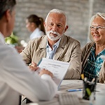 elderly couple at a dental implant consultation with their dentist