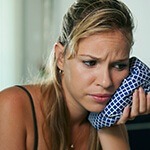 Woman holding ice pack over cheek