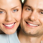 Smiling couple after full-mouth dental restoration