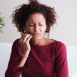 person holding their mouth in pain before scaling and root planing treatment