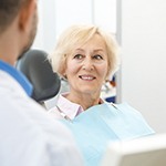 Older woman with dental implants smiling in dental chair