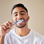 Man with dental implants in Grapevine, TX brushing his teeth