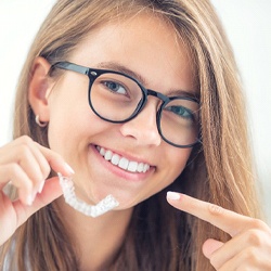 A young girl wearing glasses and being treated with Invisalign in Grapevine