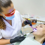 A middle-aged woman under IV sedation and having a dental procedure completed by her dentist in Grapevine