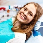 Woman smiling in dental chair after sedation dentistry