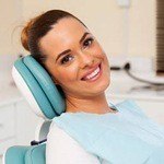 Woman smiling in dental chair after sedation dentistry