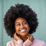 person smiling with their hands on their chin after pocelain veneers