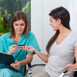 A woman using a credit card to pay the cost of teeth whitening 