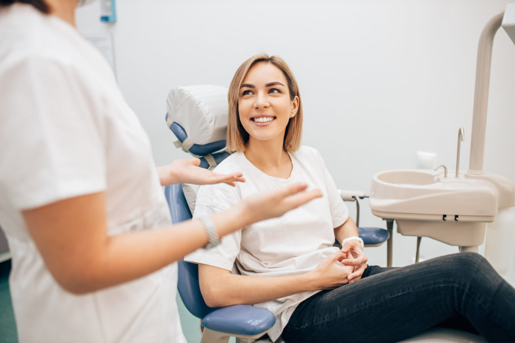 woman learning about the benefits of porcelain veneers in Grapevine