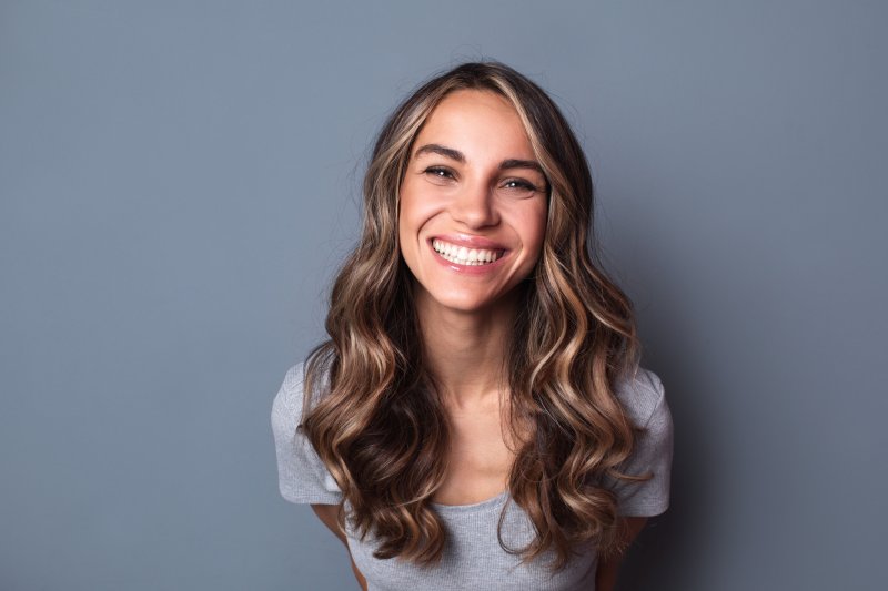 person smiling after getting porcelain veneers