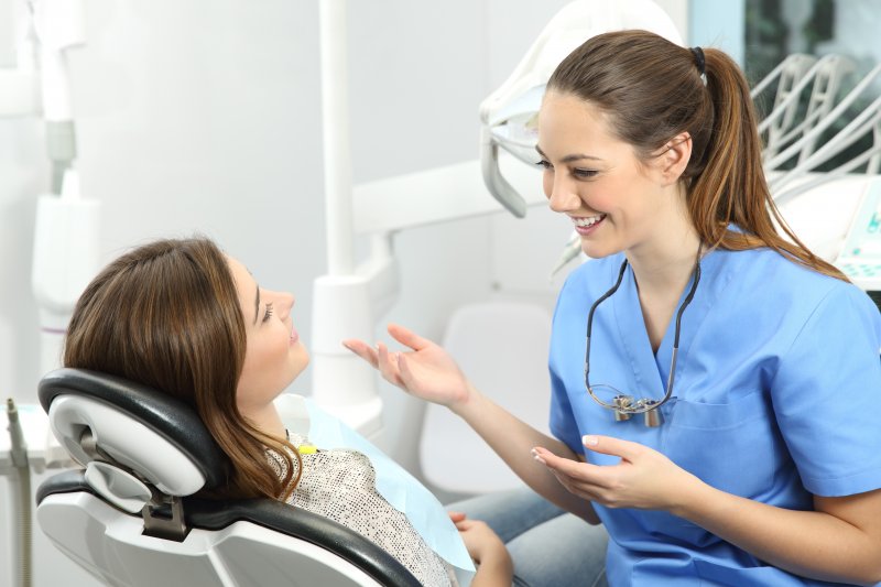 dentist talking to patient about kinds of dental crowns 