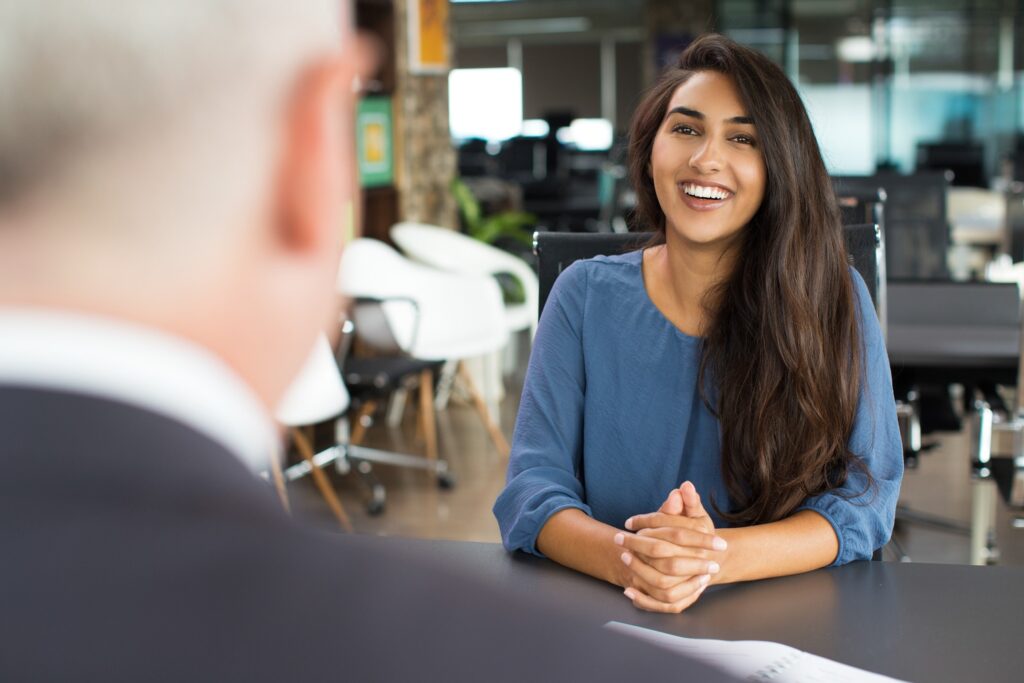 Woman in blue shirt smiling during job interview